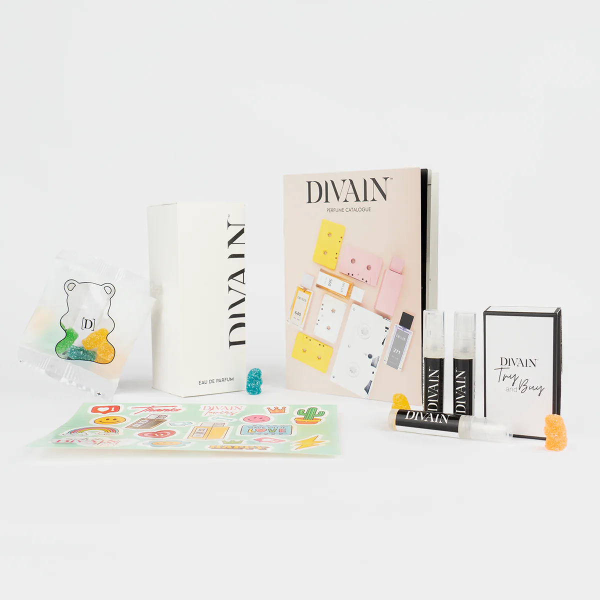 Open divain-pakket met het parfum divain-992, stickers en snoepjes
